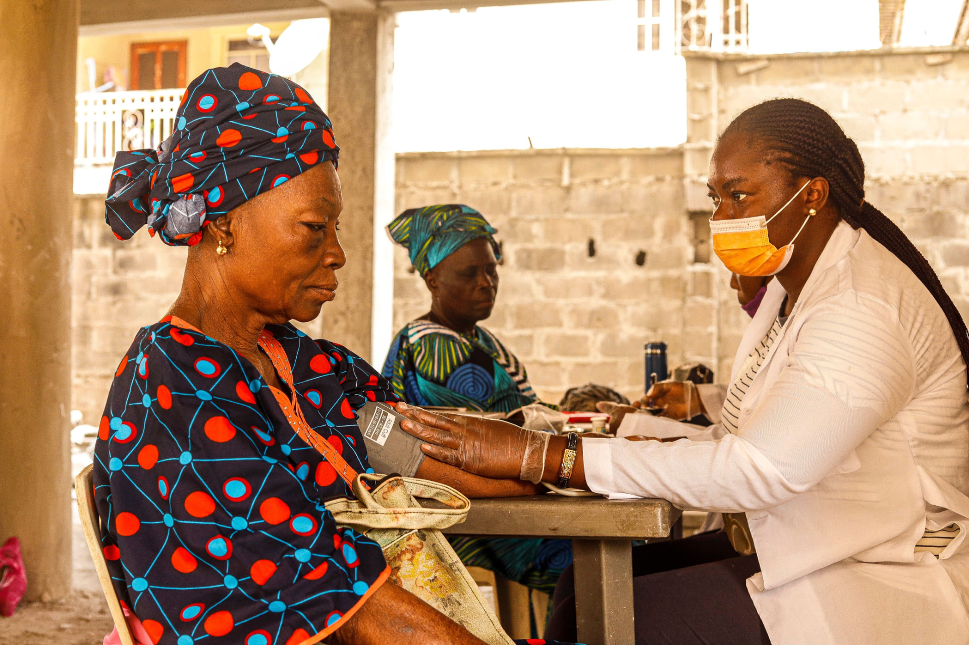 A healthcare professional checking the blood pressure of a community member during a health outreach campaign