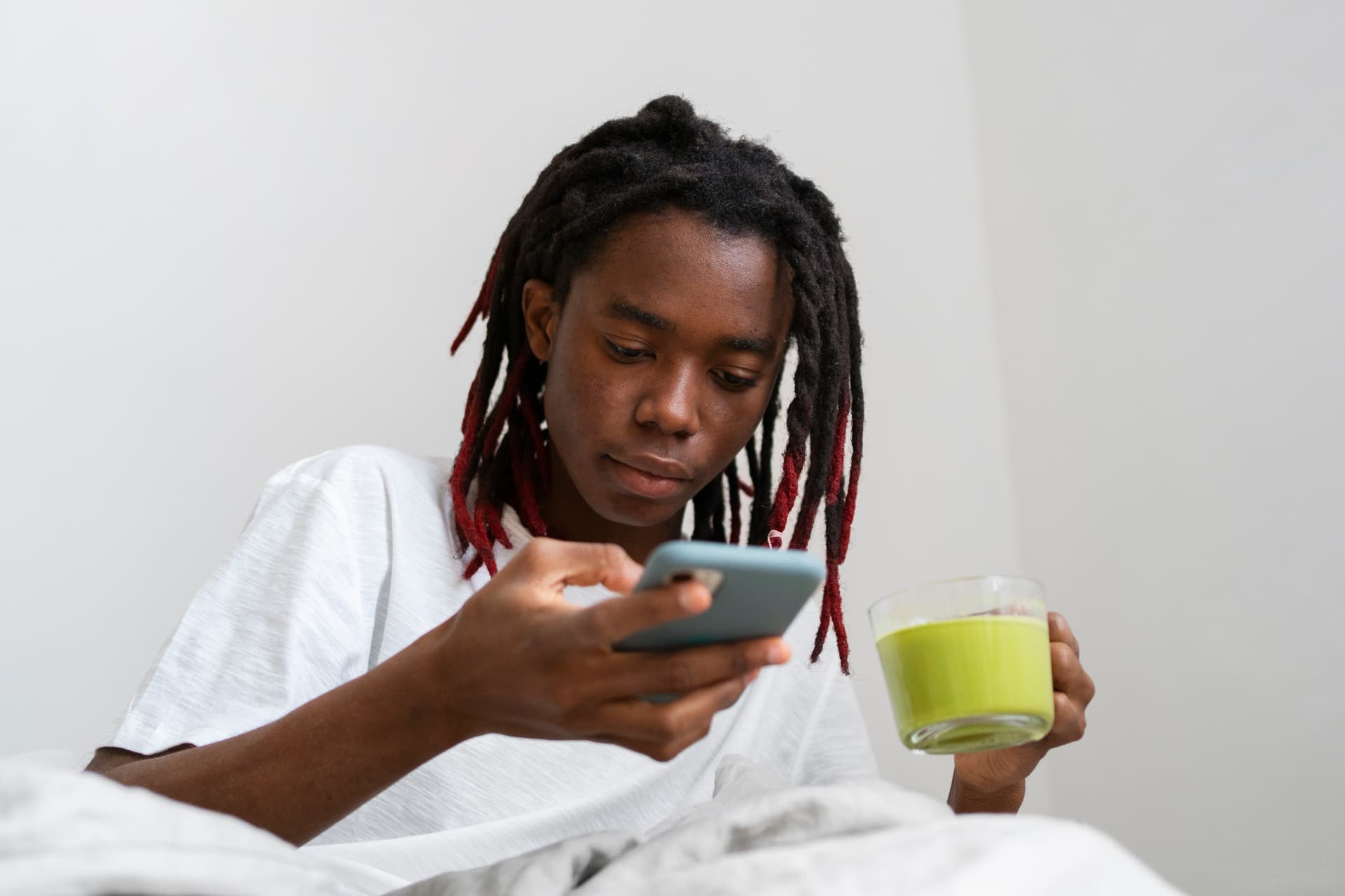 Person relaxing at home with a warm drink while checking health information on their phone